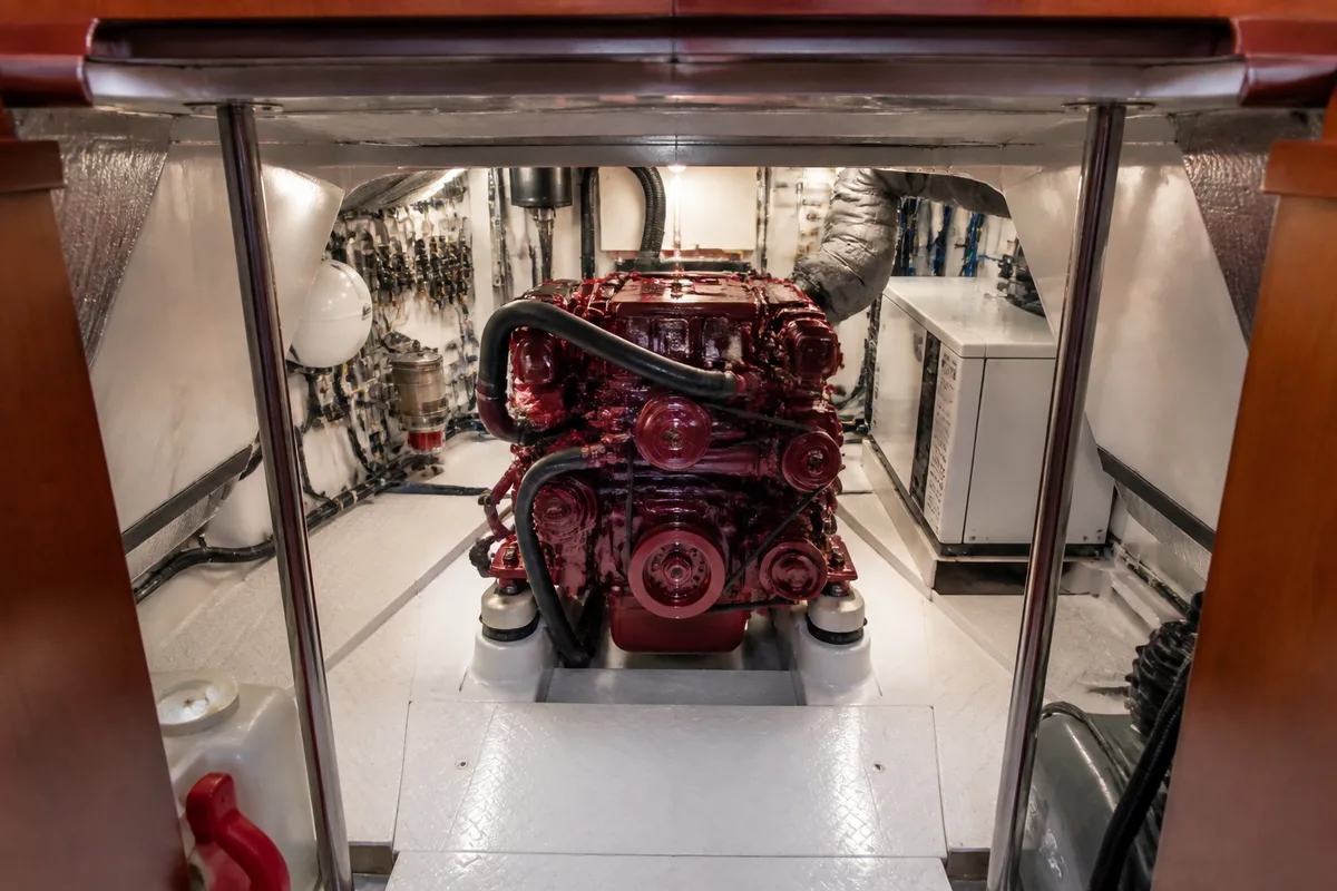 Compartiment moteur d'un bateau ouvert sur un petit diesel marin et ses circuits de refroidissement